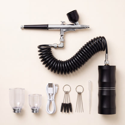 Alles wat je krijgt: airbrush met spiraalslang en compressor, twee extra verfbekers, USB-kabel, reinigingsset en pipet